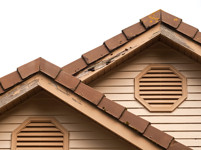 A closeup look at the eaves of a beige home that show evidence of termite damage and infestation.